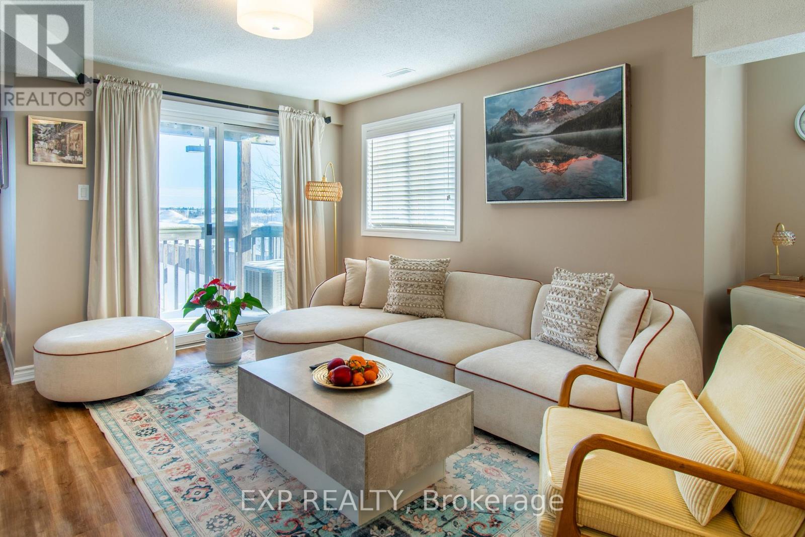 A living room with a large couch, a coffee table, and a painting on the wall.