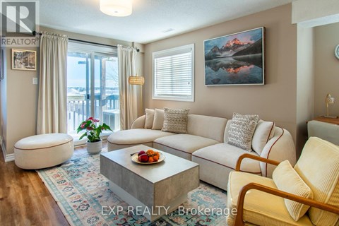 A living room with a large couch, a coffee table, and a painting on the wall.