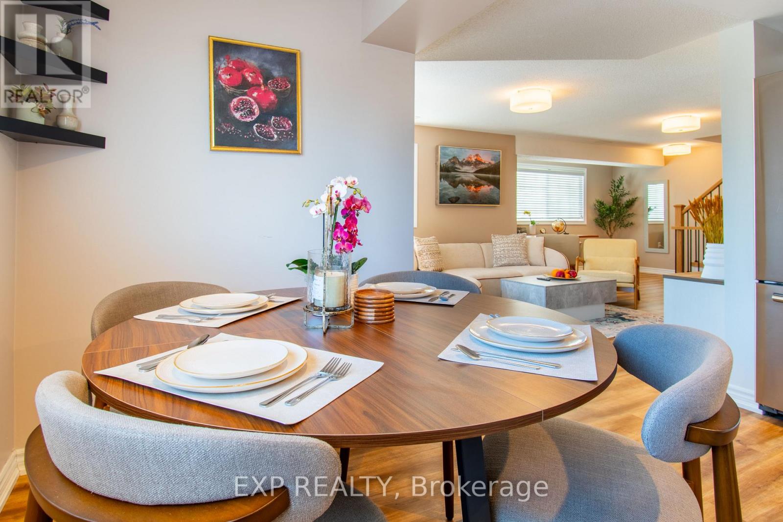 A dining room with a table set for two and a painting on the wall.