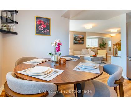 A dining room with a table set for two and a painting on the wall.
