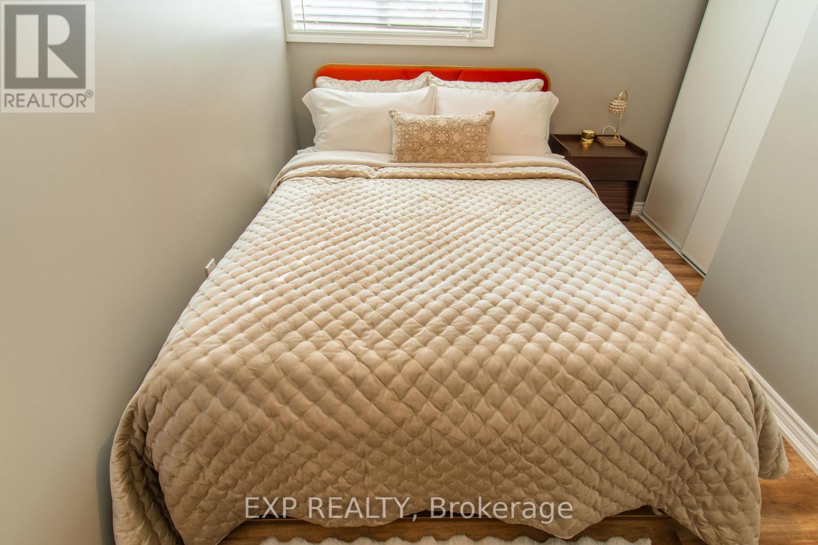 A bed with a white comforter and pillows in a bedroom.