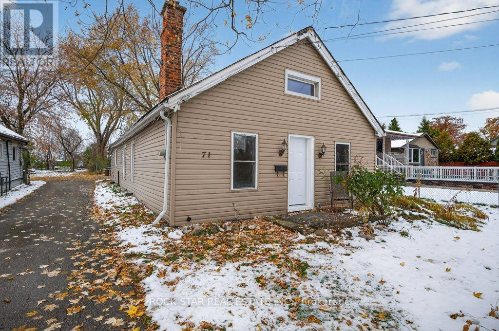 A small house with a white door and a chimney is surrounded by fallen leaves and snow.