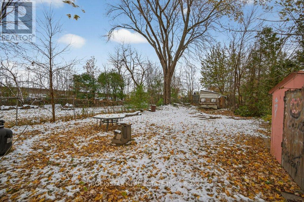 A snowy ground with a picnic table and trees in the background.