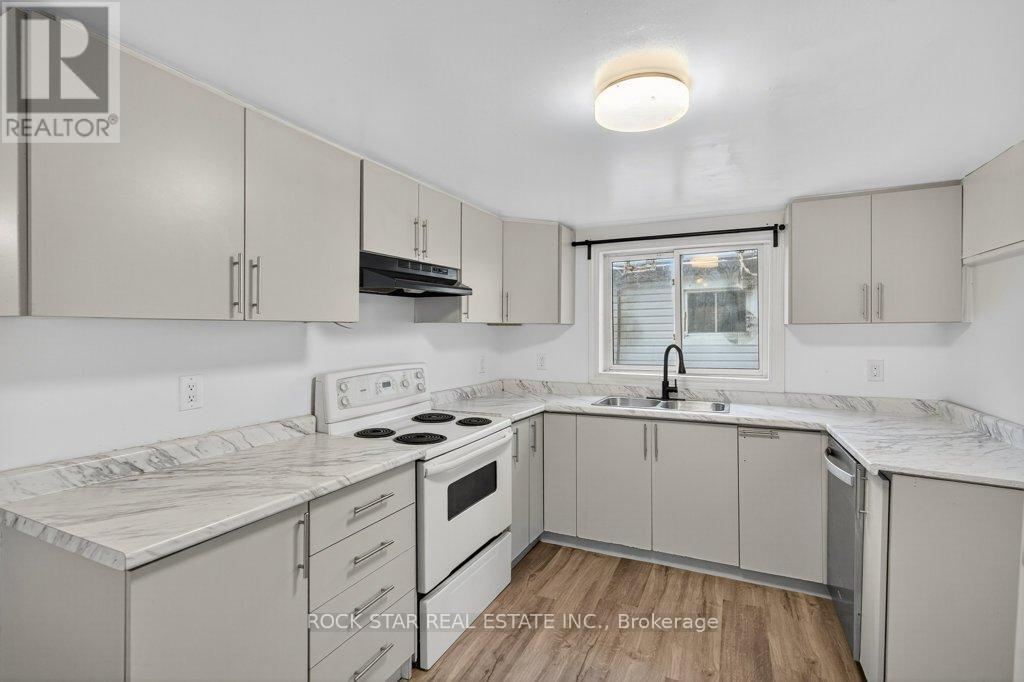 A kitchen with white cabinets and a marble countertop.