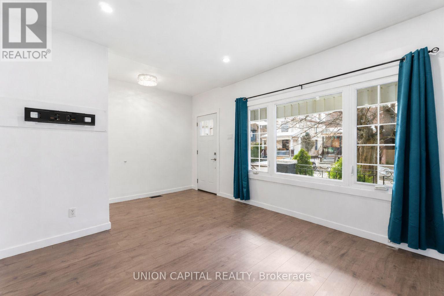 A room with a window and a door, with a sign that says "REALTOR".