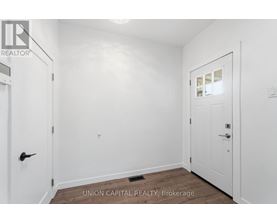 A white door is on the left and a white door with a window is on the right in a white room.