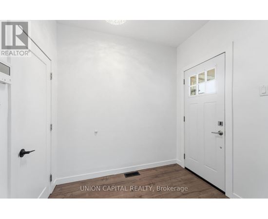 A white door is on the left and a white door with a window is on the right in a white room.