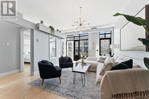 A living room with a black chair and a white couch.