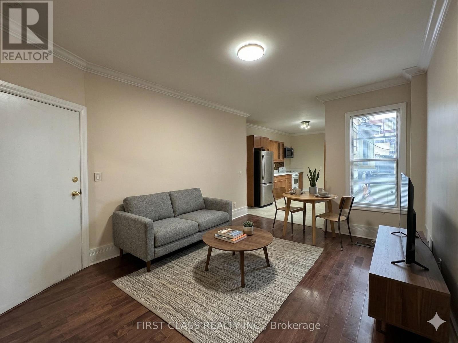 A living room with a grey couch, a coffee table, and a television.