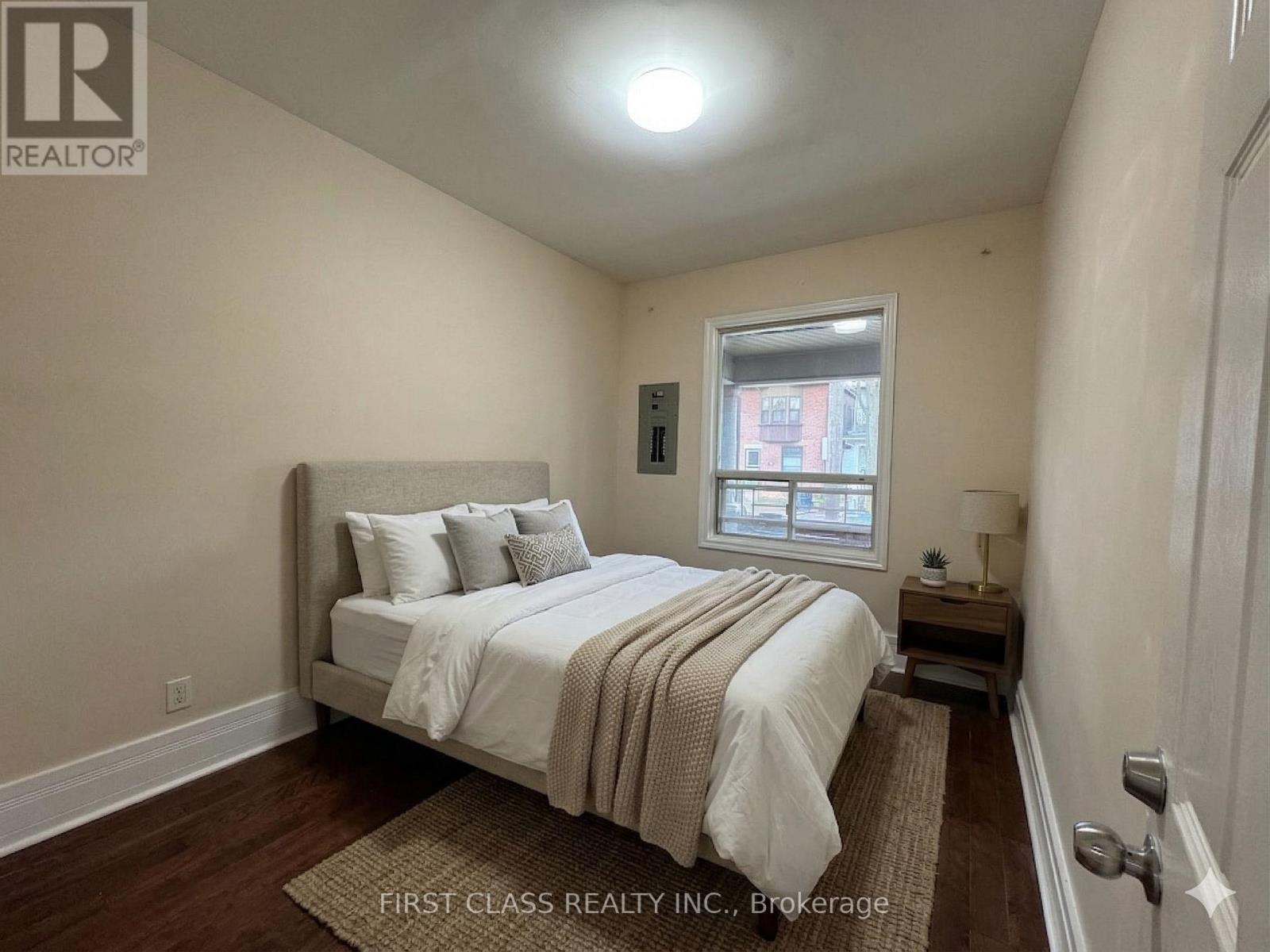 A room with wooden flooring and a window.