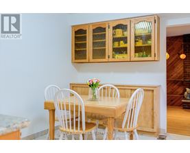 A dining room with a wooden table and chairs.