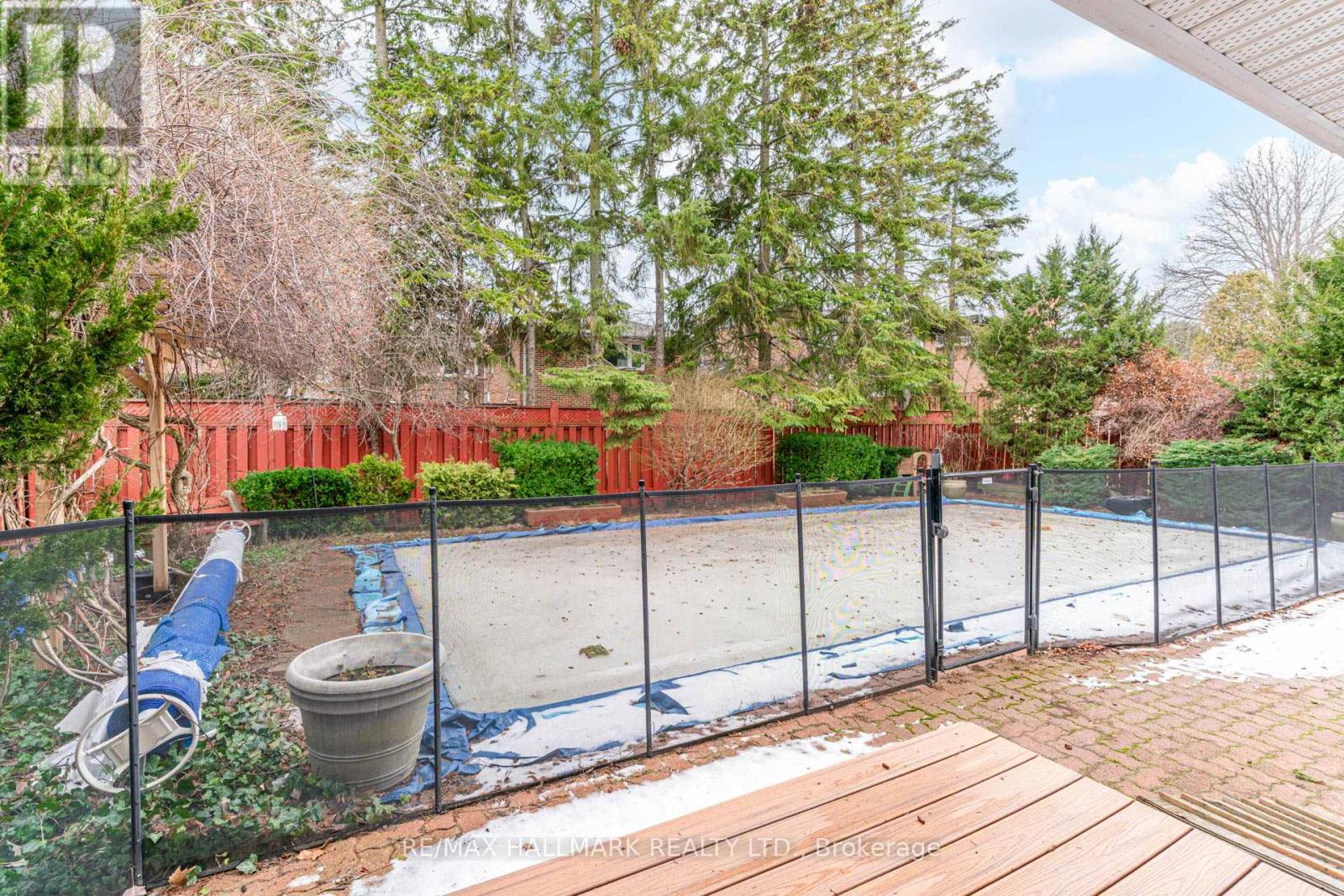 A backyard with a fenced pool and a hot tub.