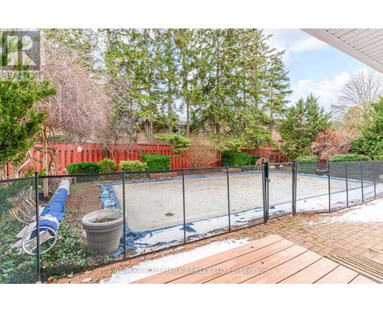 A backyard with a fenced pool and a hot tub.