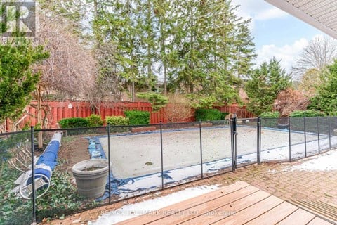A backyard with a fenced pool and a hot tub.