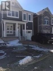A house with a white door and a black car parked in front.