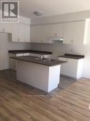 A kitchen with a white island in the middle of it.