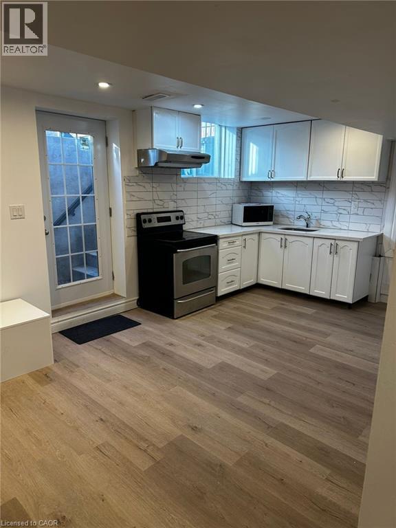 A kitchen with a black stove top oven and white cabinets.