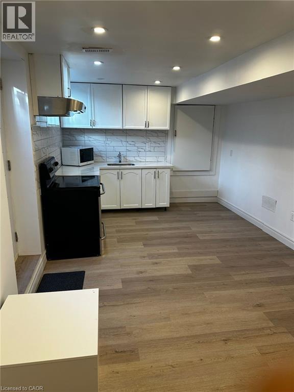 A kitchen with a black stove top oven and white cabinets.