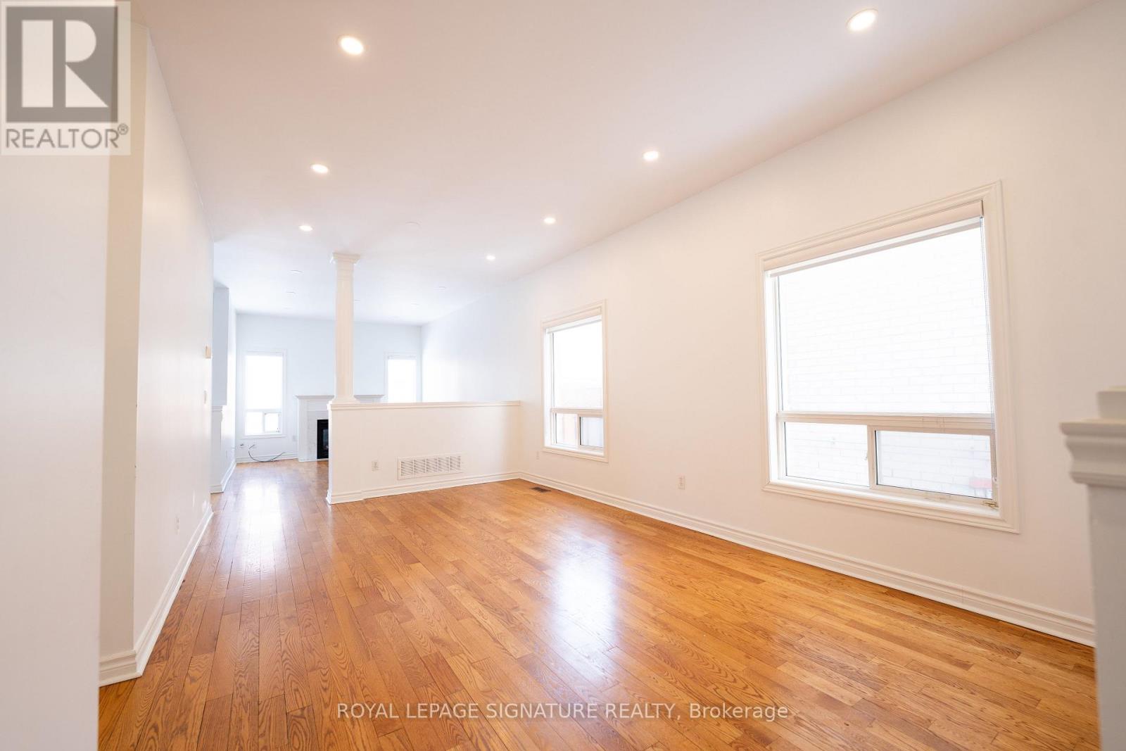 A spacious room with wooden floors and white walls.