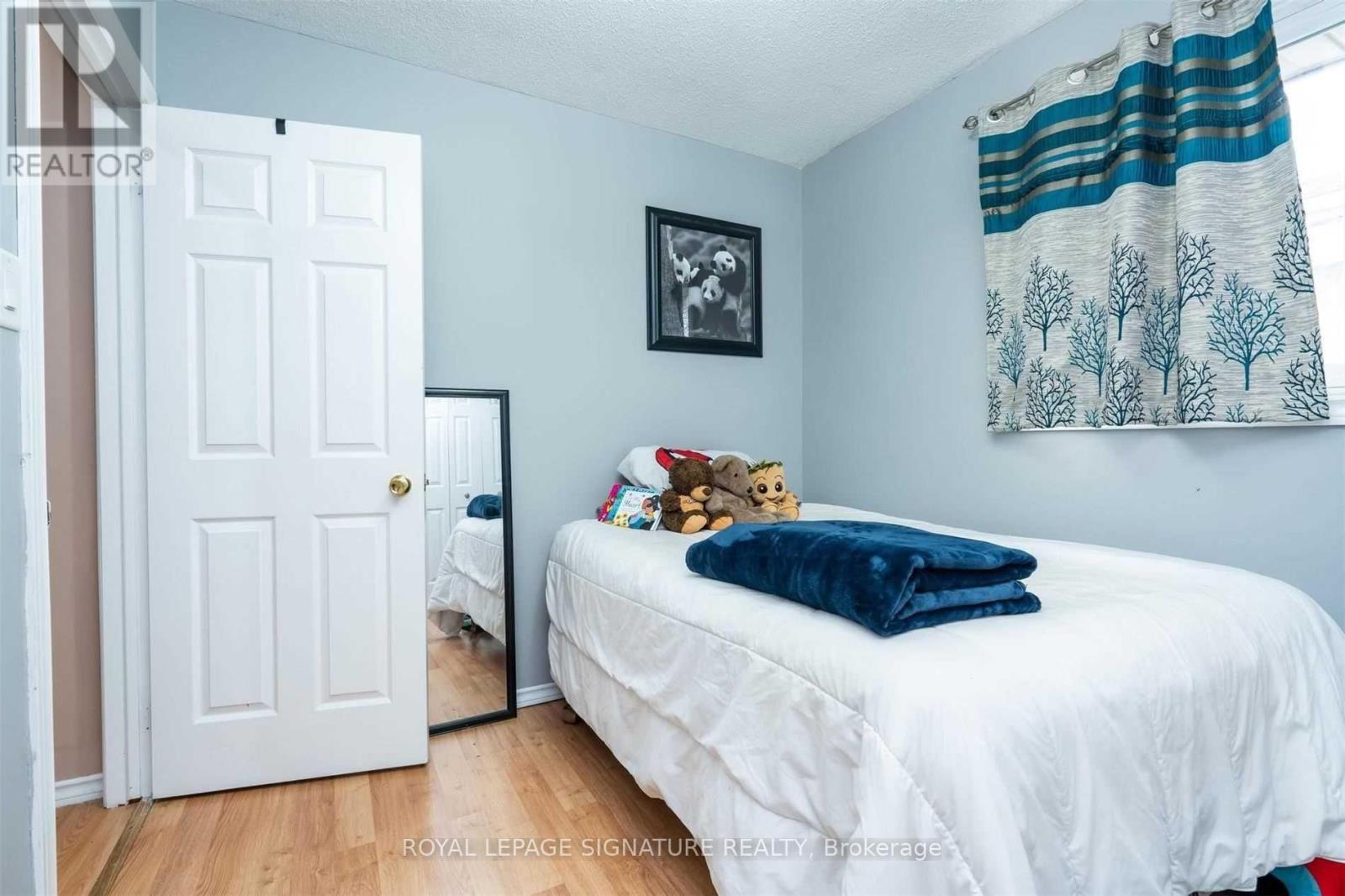 A bedroom with a white bed and a white door.