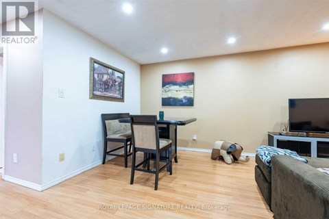 A living room with a couch, a chair, a dining table and a television.