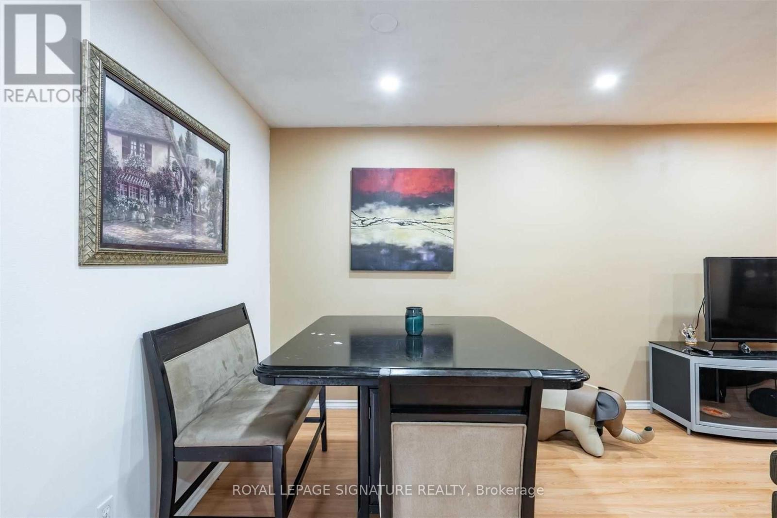 A dining room with a table, chairs and a television.