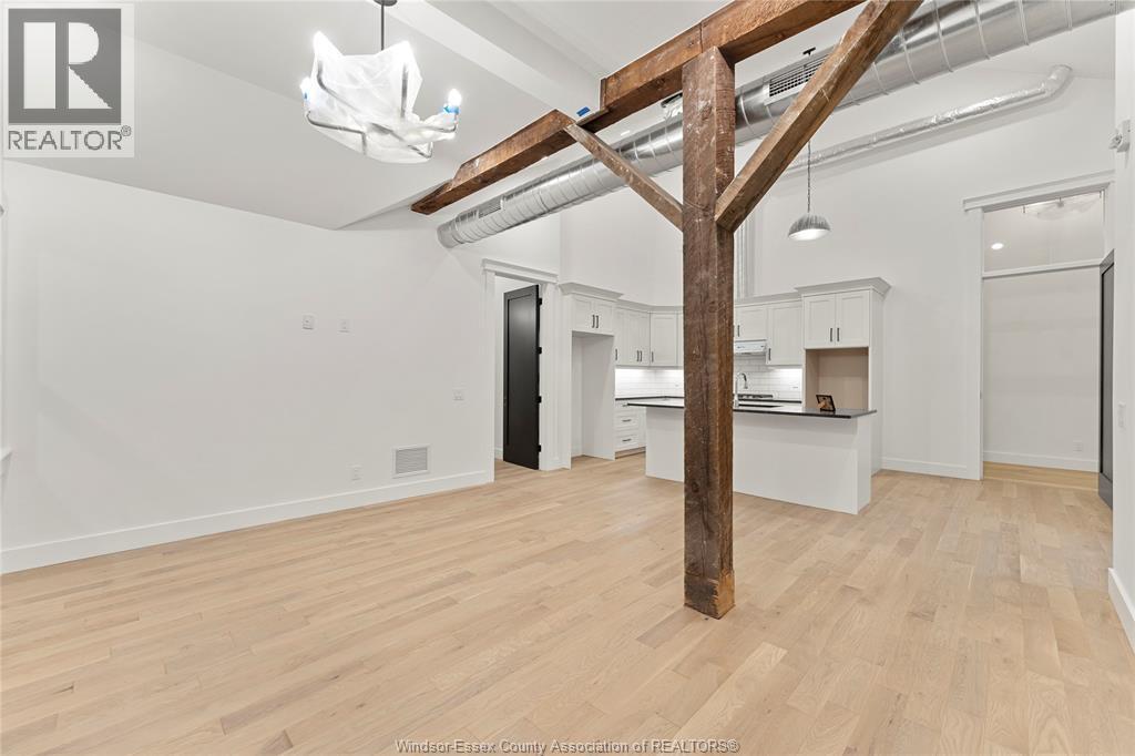 A spacious room with wooden floors and a large wooden beam structure.