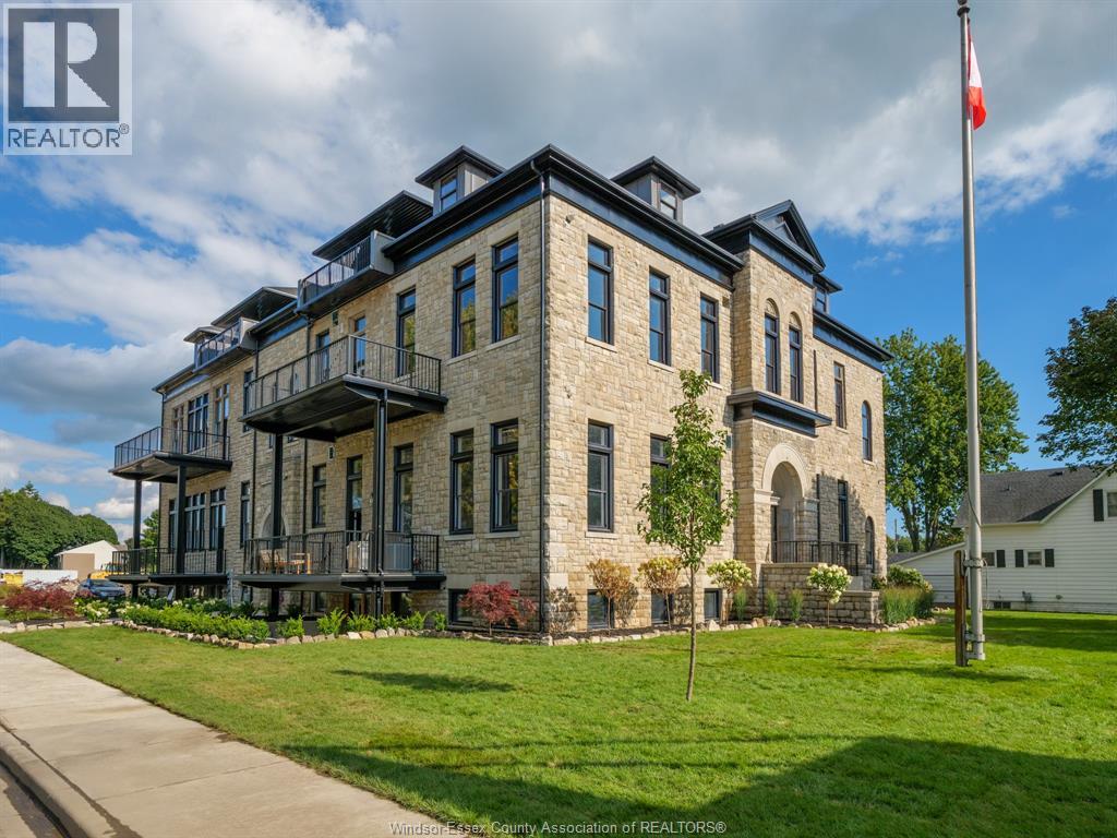 A large stone building with a balcony and a flag on a pole in front.
