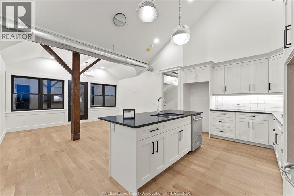 A kitchen with white cabinets and a black countertop.