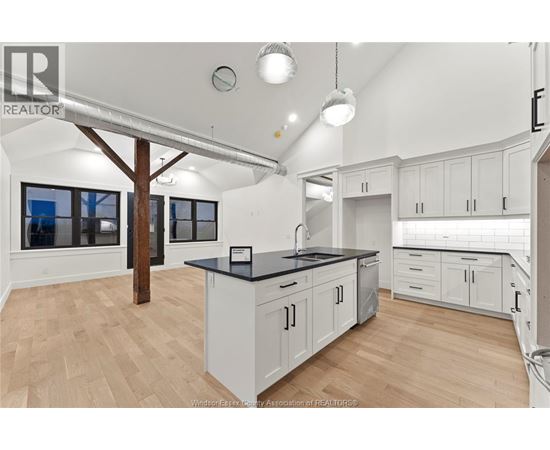 A kitchen with white cabinets and a black countertop.
