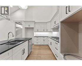 A kitchen with white cabinets and a black countertop.
