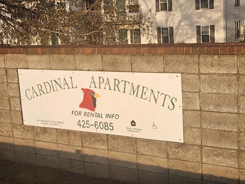 A sign for Cardinal Apartments is displayed on a wall.