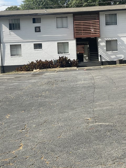 A white building with a brown door and windows.
