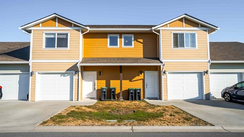 A two-story house with a garage and a driveway.