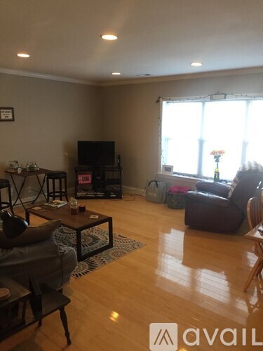 A living room with a couch, chair, and television.