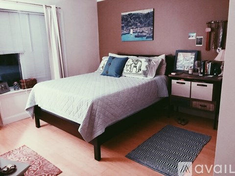A bedroom with a bed, nightstands, and a painting on the wall.