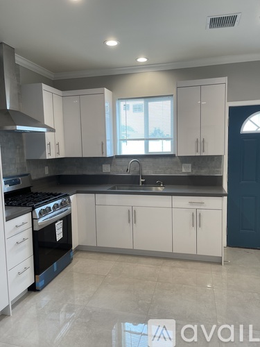 A kitchen with white cabinets and a black stove top oven.