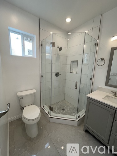 A bathroom with a toilet, sink, and walk-in shower.