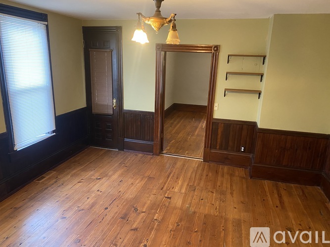 A room with wooden floors and a large mirror.