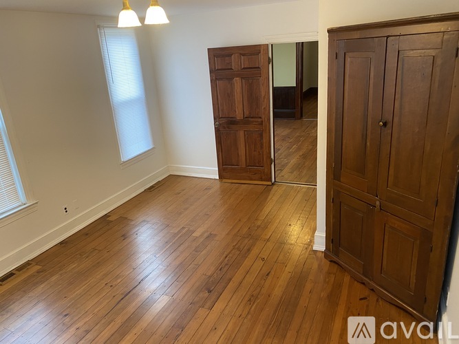 A room with wooden floors and a large wooden door.