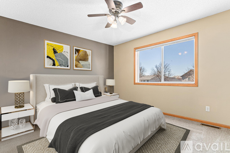 A bedroom with a large bed and a ceiling fan.