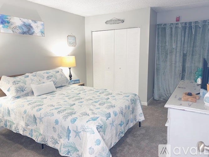 A bedroom with a bed, nightstand, and wardrobe.