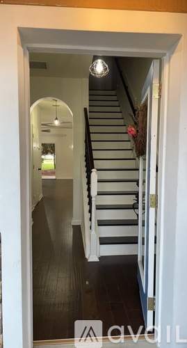 A hallway with a staircase leading to the second floor.