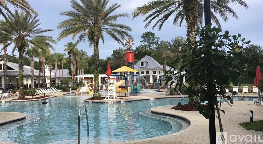 A pool area with a water slide and palm trees.