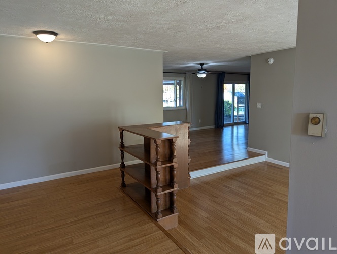 A room with wooden flooring and a large empty space.