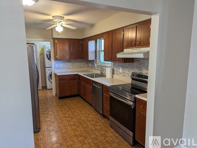 A kitchen with wooden cabinets and a refrigerator.