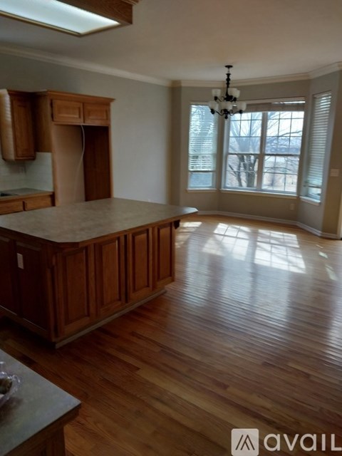 A kitchen with wooden cabinets and a marble countertop.