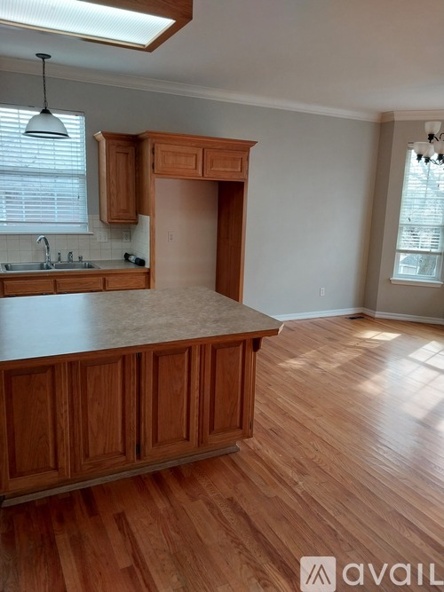 A kitchen with wooden cabinets and a marble countertop.