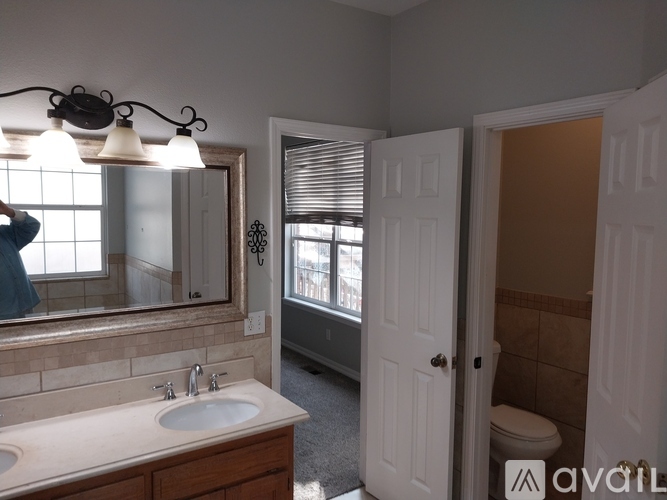 A bathroom with a sink, mirror, and toilet.