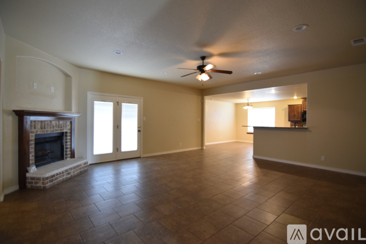A living room with a fireplace and a ceiling fan.